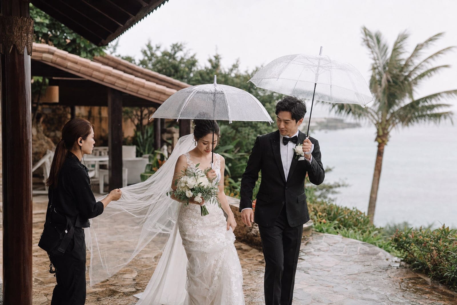 海外婚禮下雨時新人使用透明傘並由婚禮顧問協助雨備動線