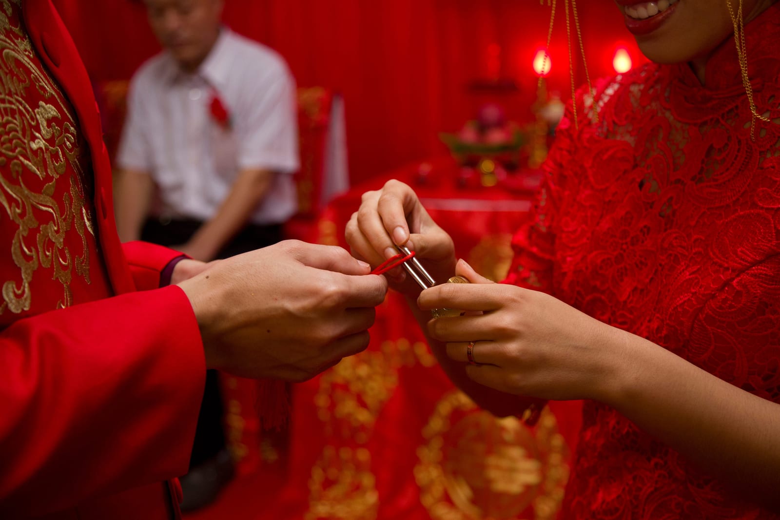 傳統紅金禮服婚禮儀式中牽手的新人